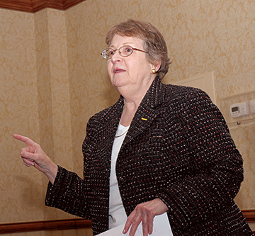 Photo of Sara McVicker, R.N. standing and addressing a group at an event